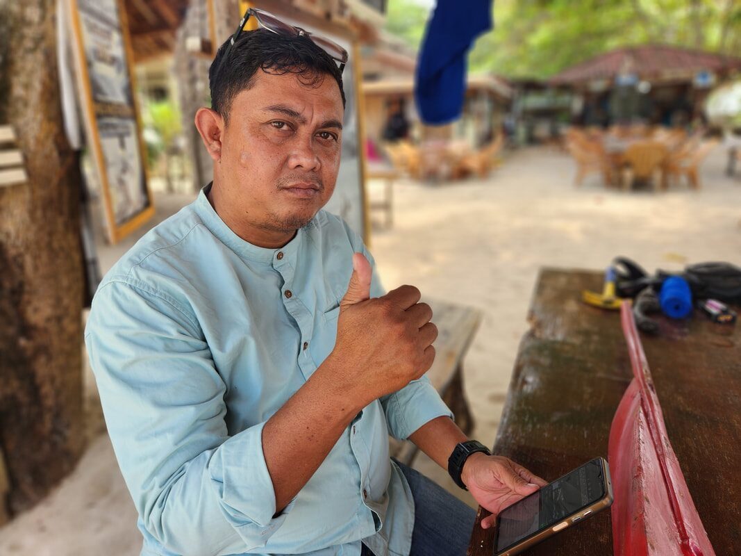 A man sitting and talking at a beachside table