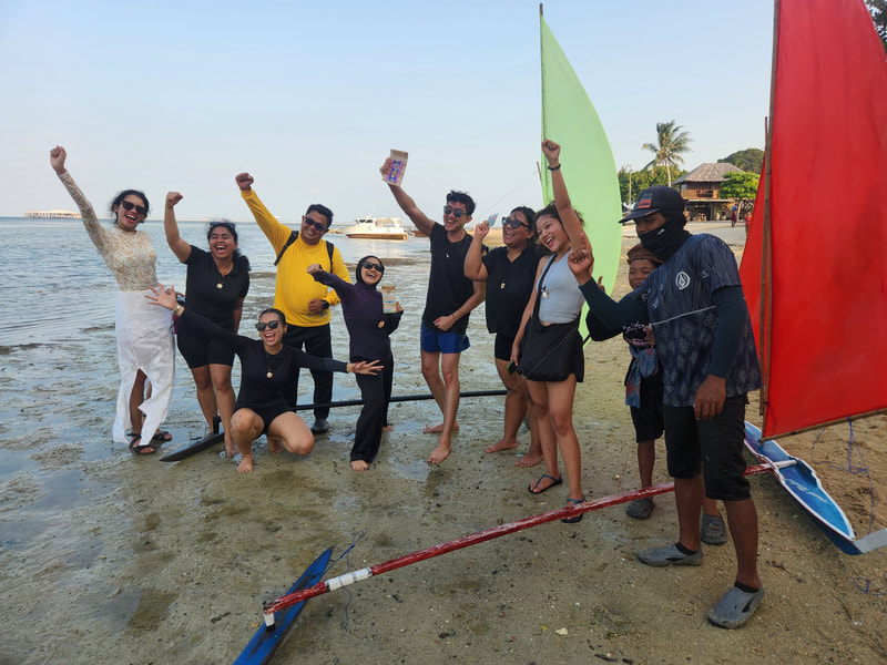 Racers and crowd celebrating on the beach at Teluk Bakau, Selatan Race 2026
